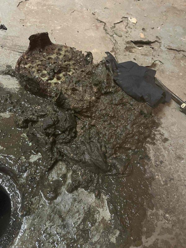 Responded to sewer backup emergency at 93-year-old residential property. Upon arrival, found significant sewage overflow in basement area with accumulated wastewater and solid waste material on concrete floor. Assessed plumbing system and determined backup was likely due to age-related deterioration of main sewer line. Cleared immediate blockage and removed debris from affected area. Documented existing conditions including water heater equipment and extent of basement flooding for insurance and repair planning purposes.