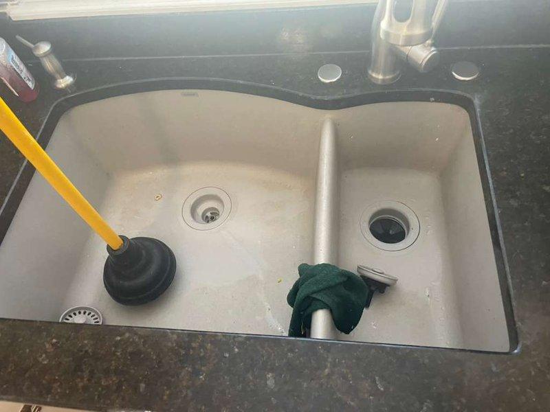 Removed existing garbage disposal unit from double-basin kitchen sink and reconfigured the drain plumbing system. Disconnected the disposal from the mounting assembly and existing PVC drain lines, then installed new pipe configuration to restore proper drainage without the disposal unit. Cleared cabinet space of cleaning supplies to access plumbing connections, completed all pipe connections with appropriate fittings, and verified system integrity with no leaks detected upon testing.