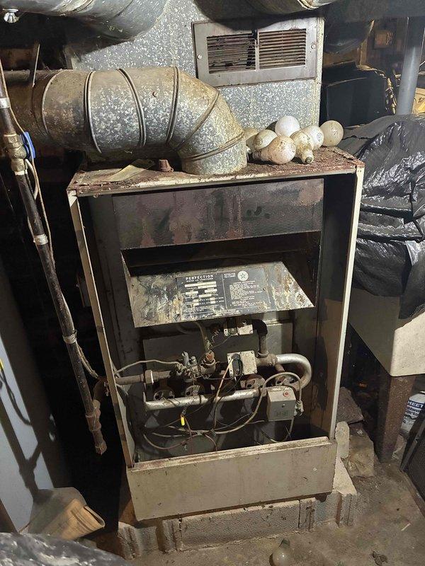 Responded to no-heat call on 20+ year old gas furnace with pilot light on but burners not igniting. Upon inspection, found aged furnace unit with open access panel revealing internal components including burners, gas valve assembly, and control mechanisms. Diagnosed failed gas valve preventing main burners from firing despite pilot remaining lit. Due to age of system and availability of parts for obsolete equipment, recommended full system replacement. Customer declined repair at this time.