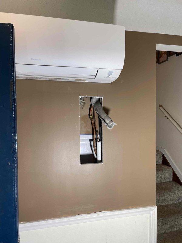 Returned to property to perform leak search on air handler system. Created access openings in interior walls to expose refrigerant lines, electrical connections, and ductwork routing between mini-split indoor unit and exterior connections. Documented exposed copper refrigerant piping, electrical conduit, and insulated line sets for inspection and leak detection purposes.