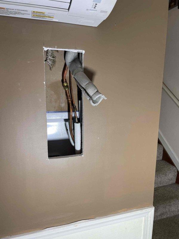 Returned to property to perform leak search on air handler system. Created access openings in interior walls to expose refrigerant lines, electrical connections, and ductwork routing between mini-split indoor unit and exterior connections. Documented exposed copper refrigerant piping, electrical conduit, and insulated line sets for inspection and leak detection purposes.