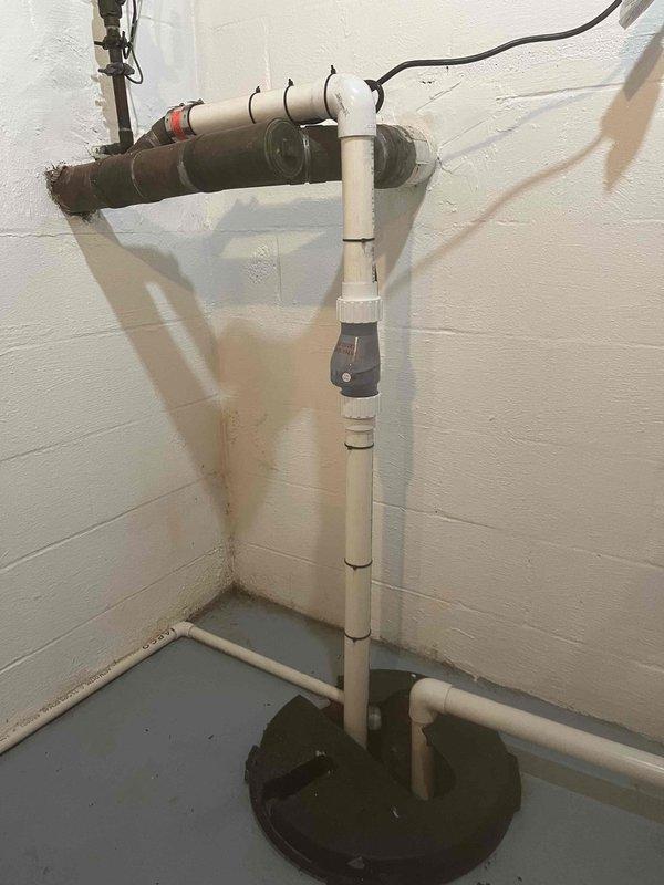 # Tankless Water Heater No Hot Water - Navien Unit

Responded to service call for 5-6 year old Navien tankless water heater not producing hot water. Upon inspection, discovered significant moisture accumulation and standing water in utility area surrounding condensate drainage system. Vertical PVC condensate drain line showed evidence of blockage with dark corrosion and residue buildup on drainage components. 

Identified compromised condensate neutralizer cartridge with heavy mineral deposits and deterioration. Standing water at floor level indicated drainage system failure preventing proper condensate removal. Cleared blockage from condensate drain line, replaced corroded neutralizer cartridge, and verified proper drainage flow. Tested unit operation and confirmed restoration of hot water delivery with proper condensate evacuation. Recommended monitoring for any recurrence of drainage issues and scheduled follow-up maintenance to prevent future condensate system failures.
