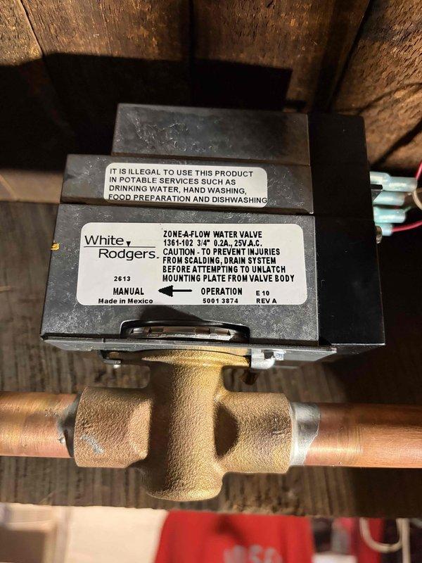 Responded to service call for leaking White Rodgers zone valve on hydronic heating system. Drained boiler, removed failed zone valve by unsweating copper connections, and installed new White Rodgers 1361-102 Zone-A-Flow valve with 3/4" connections. Soldered new valve into copper piping, refilled boiler system, and bled air from all zones to ensure proper circulation. Verified electrical connections to zone valve actuator and confirmed proper operation of heating zone. Completed boiler maintenance plan inspection including system pressure check and operational testing of all components.
