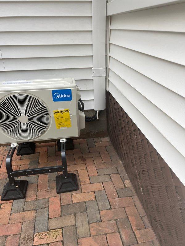 Completed installation of Midea Advanced Series mini split system with 9,000 BTU capacity, rated for operation down to -13 degrees Fahrenheit in a 1-to-1 configuration. Installation included mounting outdoor condenser unit on elevated stand over brick paver patio, installing indoor air handler, running and concealing refrigerant line set along exterior siding, and completing dedicated electrical circuit to power the system. Unit was leveled, tested, and confirmed operational upon completion.