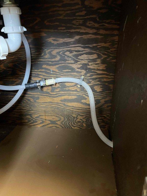 Extended dishwasher drain line under kitchen sink by installing additional PVC piping and flexible corrugated hose connections to properly route drainage. Modified existing P-trap assembly with new fittings and connectors to accommodate the extended drain configuration, ensuring proper drainage flow and code-compliant installation.