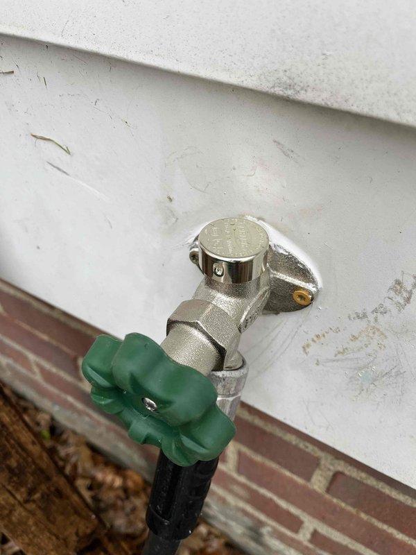 Responded to emergency call for outdoor hose bib leaking both inside and outside the residence upon activation. Inspected exterior spigot with green cross-handle valve and traced supply lines through crawl space to identify leak source at connection points between copper piping and valve assembly. Tightened brass fittings and dielectric union connections where copper pipes interface with PEX supply lines to eliminate water spray condition and restore proper function to outdoor water fixture.