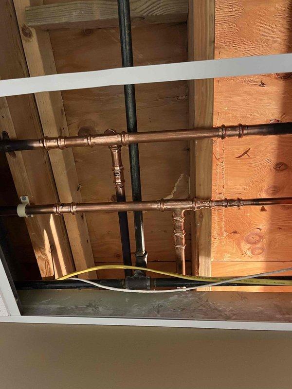 Responded to water leak in drop ceiling caused by failing copper pipe joint. Upon inspection, discovered active leak at copper elbow connection with visible water damage and moisture accumulation in surrounding area. Removed damaged section of copper piping and installed new copper fittings with proper soldering techniques to ensure watertight seal. Tested repaired connection under full pressure to verify leak was completely eliminated. Additionally, replaced exterior hose spigot as requested, removing old fixture and installing new frost-proof sillcock with proper pitch for drainage. All work completed to code specifications and system restored to full operation.