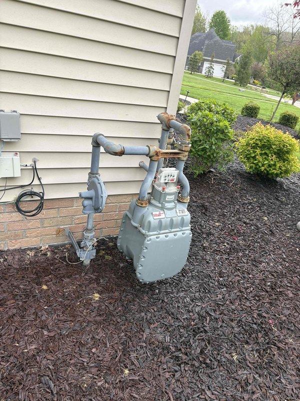 Responded to service call for 5-year-old Black and Decker tankless water heater with no hot water production since installation. Upon arrival, conducted comprehensive diagnostic assessment of the unit and associated utility connections. Inspected the natural gas supply line and meter installation at the exterior of the residence, noting visible corrosion and rust on gas line fittings and valve connections that could potentially affect gas flow to the appliance. Examined the basement mechanical room installation, including the complex PVC piping configuration and water distribution system connected to the tankless unit. Performed gas line pressure testing and verified proper gas supply availability at the meter. Identified issues with gas delivery system requiring further evaluation to restore hot water functionality to the previously non-operational tankless water heater system.