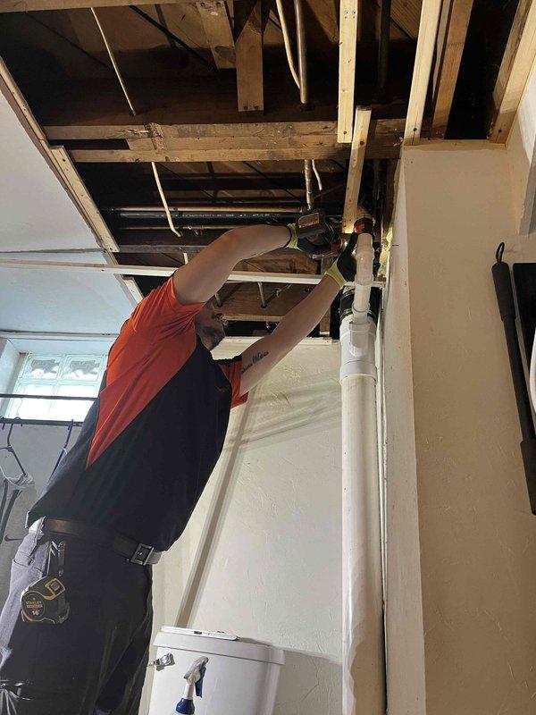 Completed repipe of severely corroded main drain stack in residential property. Accessed and removed deteriorated cast iron piping from ceiling cavity above garage area, which showed extensive rust degradation and structural compromise. Replaced failing stack with new PVC drainage system, running new pipe through exposed ceiling joists to ensure proper drainage flow. Coordinated installation to minimize disruption to existing structure and appliances in work area. All replaced materials were laid out for inspection, confirming the necessity of the replacement due to advanced corrosion. New piping system installed to current code specifications, ensuring long-term reliability of the main drainage stack.