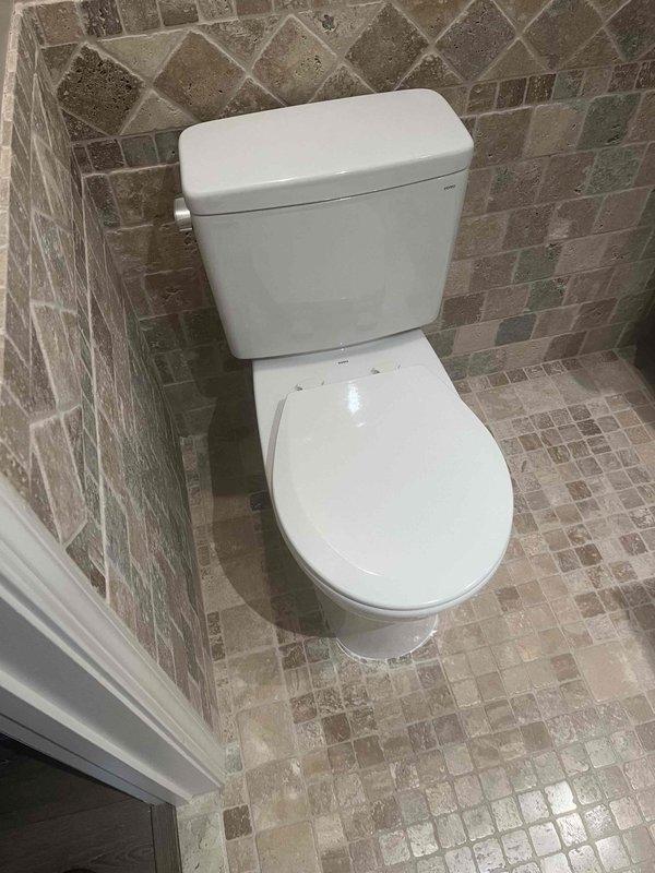 Completed toilet installation in residential bathroom, including removal of existing fixture, preparation of flange area, and mounting of new water closet. Sediment filter replacement is scheduled for follow-up visit with appropriate replacement parts, and shower head cleaning will be performed during the same service call.