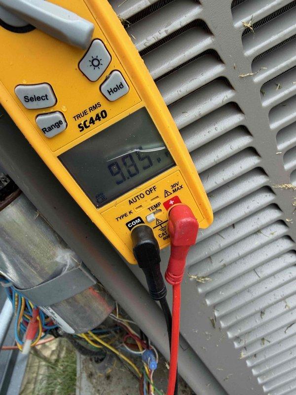 Responded to air conditioning service call for potential capacitor issue. Upon arrival, performed electrical diagnostics using digital multimeter to test voltage and amperage readings on the outdoor condensing unit. Measurements indicated system operational parameters, with readings of 985 and 113 recorded during testing. Inspected condenser coil fins, which showed accumulation of dirt and debris requiring attention. Completed diagnostic evaluation of A/C system components and electrical connections.