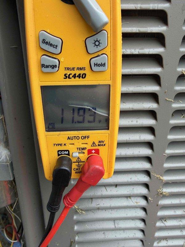 Responded to air conditioning service call for potential capacitor issue. Upon arrival, performed electrical diagnostics using digital multimeter to test voltage and amperage readings on the outdoor condensing unit. Measurements indicated system operational parameters, with readings of 985 and 113 recorded during testing. Inspected condenser coil fins, which showed accumulation of dirt and debris requiring attention. Completed diagnostic evaluation of A/C system components and electrical connections.