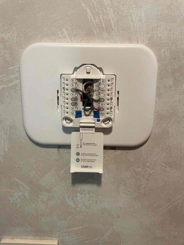 Returned to property to install previously sold motor and thermostat replacement. Removed existing Honeywell Home thermostat from wall and disconnected wiring from terminal block, documenting wire connections including R, C, W, Y, and G terminals. Installed new thermostat unit, reconnected all wiring to proper terminals per manufacturer specifications, and verified system powered on correctly with display showing indoor temperature reading. Tested thermostat operation in both system and fan modes to confirm proper communication with HVAC equipment.