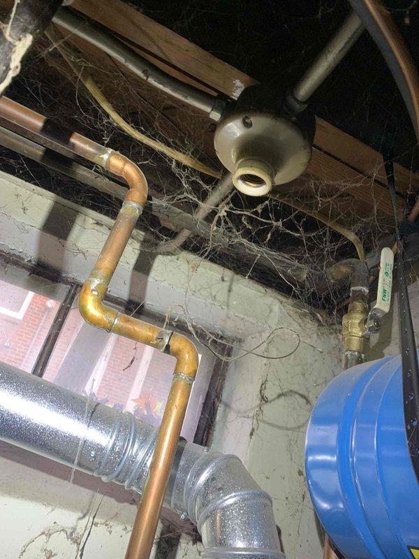 Responded to no heat call for 38-year-old furnace with no airflow. Upon arrival, inspected electrical panel and furnace system in basement utility area, documenting existing conditions including aged infrastructure with extensive dust and cobweb accumulation throughout mechanical space. Assessed system operability and provided customer with recommendations given the advanced age of the equipment beyond its expected service life.