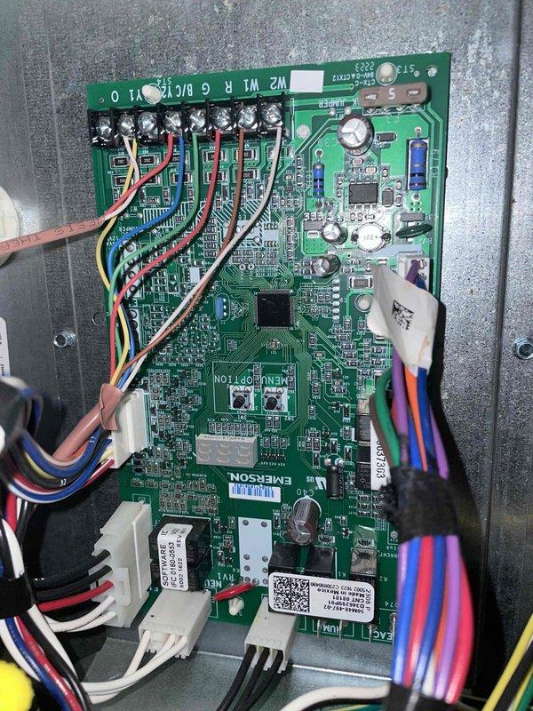 Completed cooling maintenance on HVAC system per customer request for technician continuity. Performed diagnostic testing using digital multimeter to verify electrical readings at control board, confirming proper voltage levels at 396V and system operation within manufacturer specifications. Inspected Emerson control board and all associated wiring connections, terminal blocks, and electronic components for signs of wear or deterioration—all found to be in good working condition with clean solder joints and secure connections.