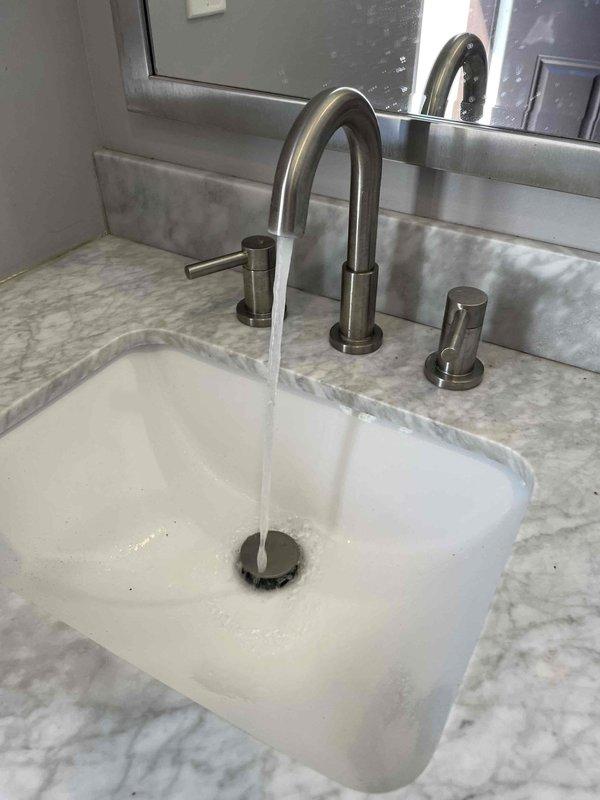 # Plumbing Service - De-Winterization of Pool House

Performed complete de-winterization service for pool house plumbing system. Restored water supply to all fixtures and verified proper operation throughout the facility. Testing included running water through bathroom vanity faucet to confirm adequate flow and pressure, and added tracer dye to toilet tank to check for leaks in fill valve, flapper, and flush mechanism. All fixtures tested successfully with no leaks detected and proper drainage confirmed.