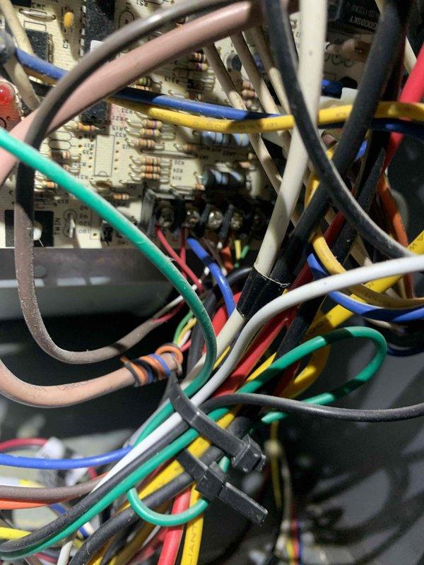 Responded to callback for continuously running air handler fan drawing 65 watts. Inspected thermostat wiring connections and verified proper terminal assignments at both the wall control and air handler control board. Found thermostat G-terminal wire connection causing fan to run in continuous mode rather than automatic cycling. Corrected wiring configuration, tested system operation through multiple heating and cooling cycles, and confirmed air handler fan now operates properly in auto mode with appropriate on/off cycling.