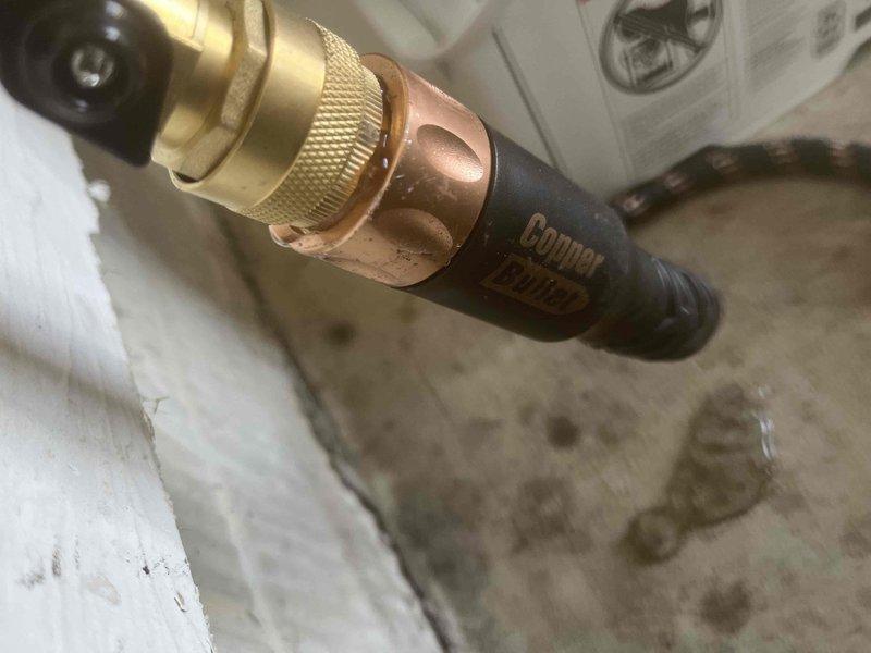 Responded to service call for leaking outdoor spigot and malfunctioning garbage disposal. Inspected and documented water pressure regulation system, including pressure reducing valve assembly with gauge reading and copper piping connections. Replaced non-functional garbage disposal unit and addressed outdoor spigot leak to restore proper operation of both plumbing fixtures.