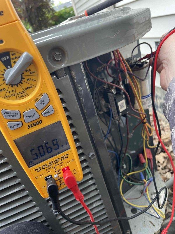 Completed comprehensive AC tune-up on five-year-old air conditioning system with no reported issues. Performed electrical diagnostics using multimeter to verify voltage readings at 240.6V, tested capacitor functionality, and inspected all wire connections and terminals within the condensing unit. All components operating within normal parameters; system maintenance completed successfully.