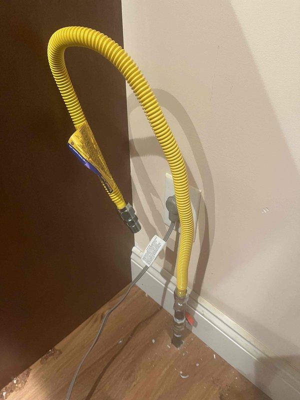Responded to red-tagged gas line serving kitchen stove following repeated gas odor complaints. Pulled stove from installation position to access yellow CSST gas line and connections. Performed comprehensive pressure test on gas line system, inspected all fittings and connections at appliance termination point and wall-mounted valve assembly. Verified system integrity, confirmed no leaks present, and cleared red-tag status. Reinstalled stove to original position and restored gas service for safe operation.