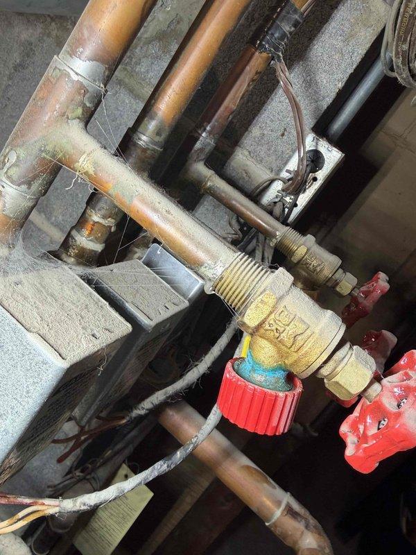 Responded to service call for reported boiler leak in residential heating system. Upon inspection, identified active leak at aged brass valve fitting on primary heating loop with visible corrosion and deterioration on copper piping connections. Documented condition of existing mechanical components showing advanced oxidation and patina buildup indicative of long-term moisture exposure. System requires valve replacement and potential repiping of affected sections to restore proper operation and prevent further water damage.