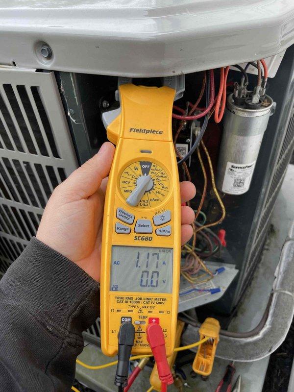 Performed routine HVAC maintenance club visit on 4-ton air conditioning system with air handler renewal. Conducted electrical diagnostics using digital multimeter, measuring current draw of 1.17 amps with system operating. Inspected internal components including capacitor, wiring connections, and control circuits. Referenced manufacturer airflow tables to verify proper CFM specifications for unit model and tonnage, confirming system is operating within design parameters for cooling mode.