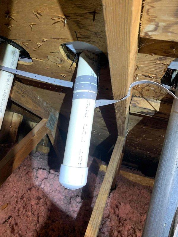 Responded to callback following recent fresh air intake installation after heavy rainfall. Inspected PVC intake pipe installation running through attic space and roof penetration. Verified proper mounting and securing of intake pipe to roof framing members with appropriate brackets and straps. Examined rubber boot flashing at roof penetration point for proper seal and water intrusion. Confirmed all components properly installed with no leaks or water damage to system despite torrential rain conditions.