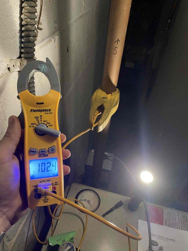 Returned to property to install new 5" vent damper on boiler system and complete boiler maintenance plan service. Installed vent damper assembly on flue pipe, verified proper operation and electrical connections reading 102.9 on meter diagnostics. Performed comprehensive boiler maintenance including burner inspection, cleaned burner assembly compartment which showed signs of rust and corrosion, checked all safety controls and wiring connections, and confirmed system operational parameters within manufacturer specifications.