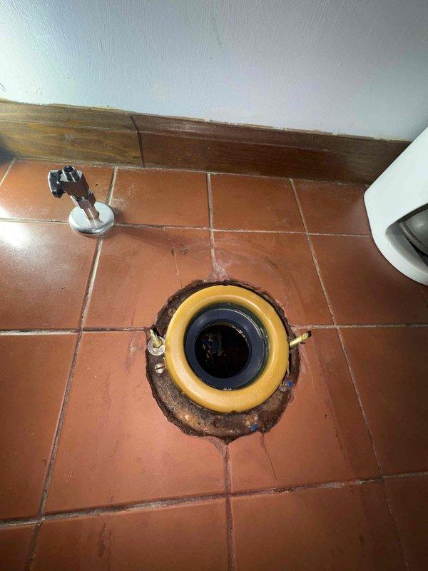 Returned to property to complete plumbing work previously sold. Removed and reset toilet, replacing wax ring seal and addressing previous water damage evident on terracotta tile flooring around flange area. Inspected toilet flange for proper alignment and secure mounting, confirmed bolts and hardware properly seated. Verified handheld shower fixture installation and connections in bathroom with freestanding tub, ensuring all chrome fixtures were leak-free and functioning correctly. All plumbing components tested and left in proper working order.