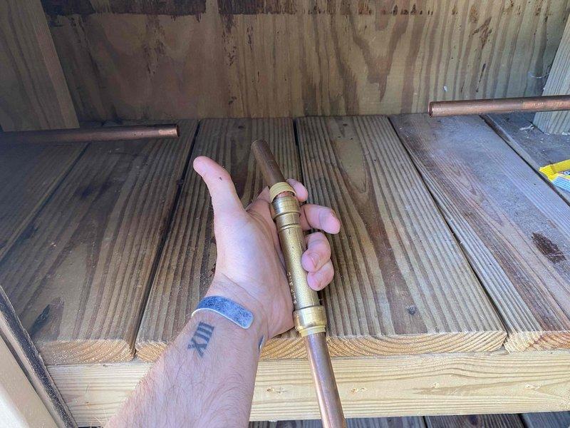 Responded to water leak caused by failed SharkBite fitting that resulted in pipe failure. Removed the defective push-fit connection and properly sweated copper pipe using traditional soldering methods to create a permanent, leak-free joint. Customer provided replacement materials for the repair. Accessed plumbing through crawl space area where copper supply line runs along floor joists above insulation layer. Successfully restored water system integrity and tested connections to ensure proper seal with no active leaks.