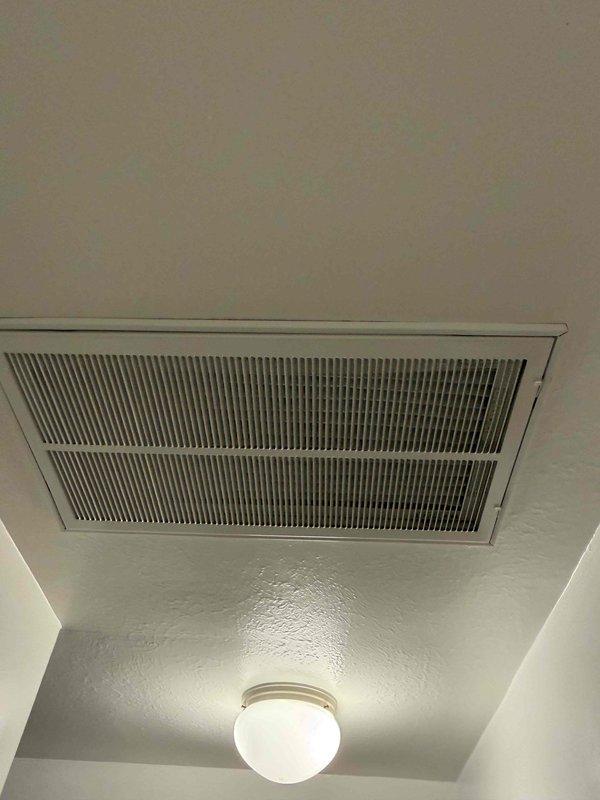 Completed routine cooling maintenance for club member's air handling system. Inspected and documented pleated air filter condition in basement mechanical room, noting proper installation in metal housing with adequate airflow capacity. Verified ceiling-mounted return air grille in interior space showing clean operation with no obstructions or excessive dust accumulation. System components operating within normal parameters with no deficiencies identified during inspection.
