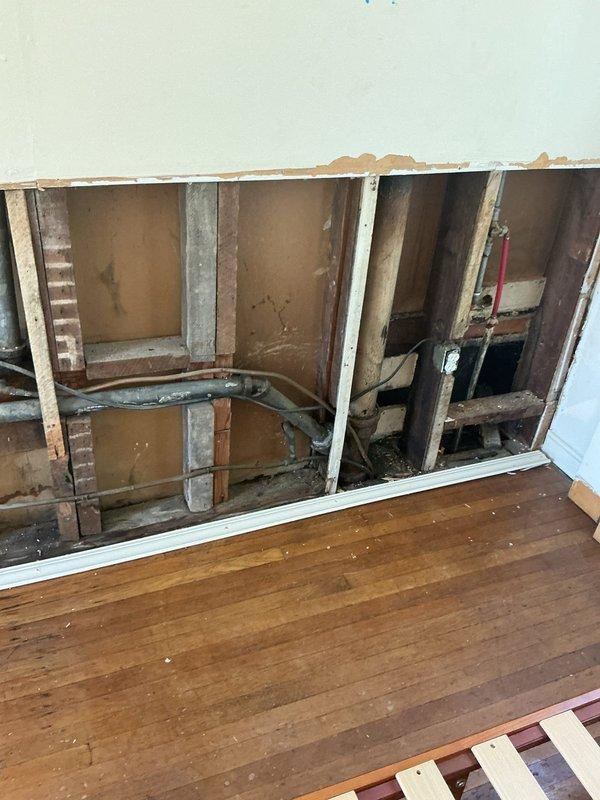 Responded to service call for cast iron pipe evaluation and plumbing modifications. Opened interior wall to access existing plumbing infrastructure and assess condition of aging cast iron piping system. Evaluated deteriorated cast iron pipe requiring future replacement due to age and condition. Capped off abandoned piping from previous kitchen installation to prevent potential leaks and ensure system integrity. Installed shut-off valves for bathroom sink to provide localized water control and facilitate future maintenance. Wall cavity remains open for additional plumbing work and final restoration.