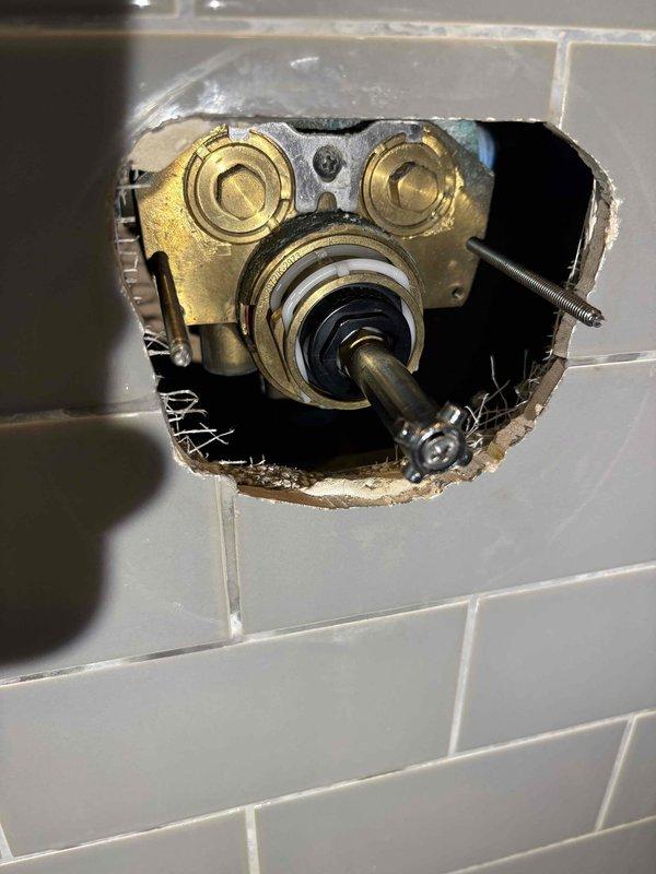 Returned to complete shower valve cartridge and balancing spool replacement in master bathroom shower after materials arrived. Accessed the mixing valve assembly through the tiled wall opening, removed the old cartridge mechanism, and installed the new cartridge and balancing spool to restore proper temperature control and water flow. Reassembled the valve components, tested the shower system for proper operation and temperature mixing, and verified no leaks were present at the valve body or connections.