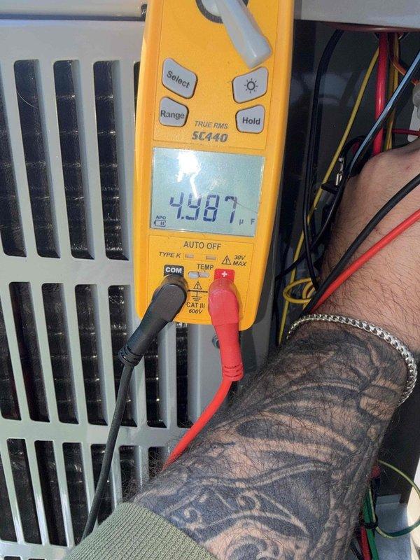 Completed prepaid club maintenance visit on air handler unit. Performed electrical diagnostics using multimeter, measuring amperage draw at 0.57A and testing capacitor which read 4.987μF. Verified proper electrical operation and documented system performance with diagnostic readings.