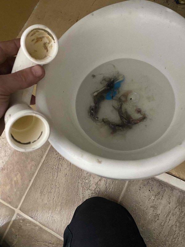 Responded to service call for multiple clogged drains including bathroom tub and sink, plus kitchen sink. Bathroom tub blockage was caused by hair accumulation. Removed and inspected P-trap assembly under sink, replaced worn O-ring seal on drain connections. Cleared debris from affected drains and verified proper water flow through all fixtures. All drainage systems restored to normal operation.