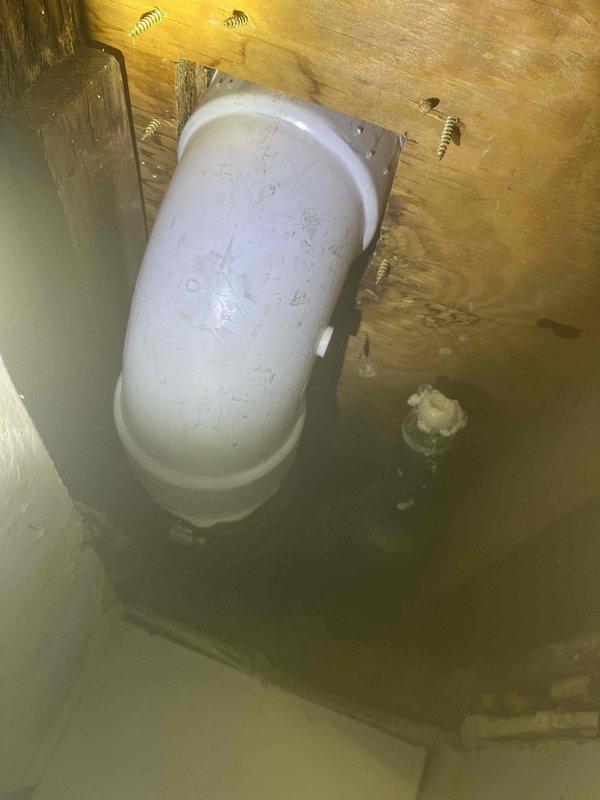Returned to property to complete plumbing repair work that was previously sold. Installed PVC pipe elbow joint with proper mounting bracket in crawl space area, securing the fitting to wooden framing with appropriate hardware. Verified proper alignment and support of drainage piping system. Documented completed installation with photographs showing the secured white PVC elbow joint mounted against structural wood beams. Work completed successfully with all connections properly fastened and functional.