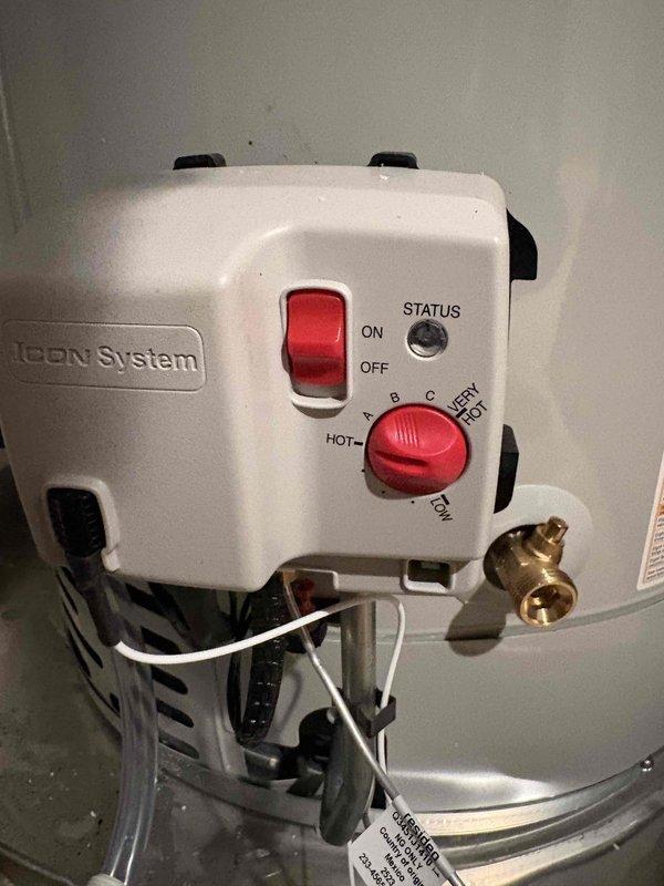 Responded to emergency call for major plumbing leak in approximately twenty-year-old residential property. Upon inspection, identified leak source at sink drain assembly and water heater control system. Inspected under-sink plumbing connections including P-trap, chrome tailpiece with rubber gasket and locknut, and braided stainless steel supply lines. All connections appeared secure with no visible signs of deterioration at basin drain assembly.

Examined water heater Icon System control unit, noting ON/OFF rocker switch and temperature dial with settings ranging from standard to very hot positions. Inspected brass valve connections and associated white tubing beneath control panel. Traced leak to compromised connection point requiring adjustment and resealing. Tightened all accessible fittings, verified proper gasket placement, and tested system integrity under normal operating pressure.

Documented conditions with photographic evidence showing plumbing components, control systems, an
