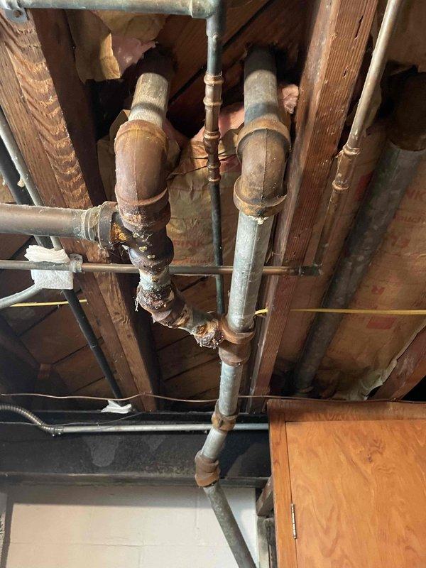 Responded to service call for slow draining bathtub with suspected clog in basement drainage system. Upon inspection, identified severely corroded cast iron drain pipes in basement with extensive rust deterioration and surface degradation affecting drainage performance. Documented existing plumbing infrastructure showing aging metal pipes with heavy oxidation at joints and connections. Provided assessment and quote for replacement of deteriorated cast iron drainage piping with PVC pipe system to restore proper drainage function and eliminate slow drain issue.