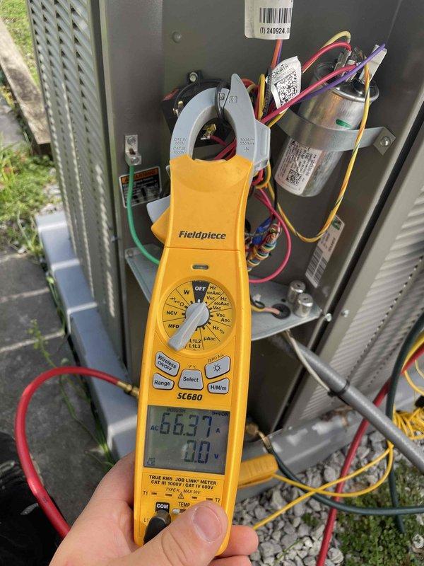 Completed routine air conditioning maintenance for club member. Performed electrical diagnostics using clamp meter, recording amp draw of 66.37 amps on the condensing unit. Inspected all electrical connections, capacitor, and wiring within the outdoor unit panel. Verified proper operation of the blower wheel assembly, which showed clean blades and no signs of wear or contamination. All components found to be in good working condition with standard installation configurations.