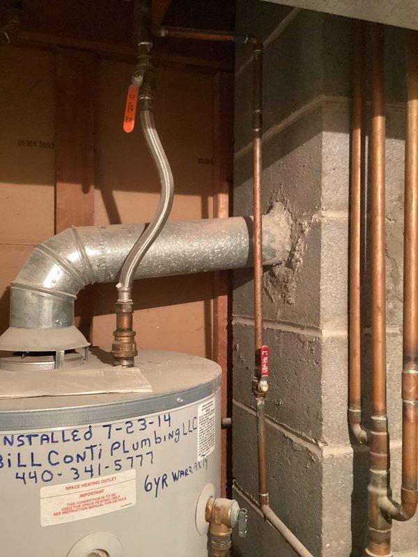Completed HVAC estimate for boiler replacement due to active leak in existing unit. Assessed basement mechanical room containing aging boiler system with associated plumbing infrastructure, humidifier components, and copper piping network. Documented existing equipment configuration including water heater installed in 2014, multiple shut-off valves, and ductwork connections. Photographed current system layout showing concrete block walls, exposed floor joists, and utility connections to provide comprehensive replacement proposal. Identified need to coordinate sump pump relocation in conjunction with new boiler installation.