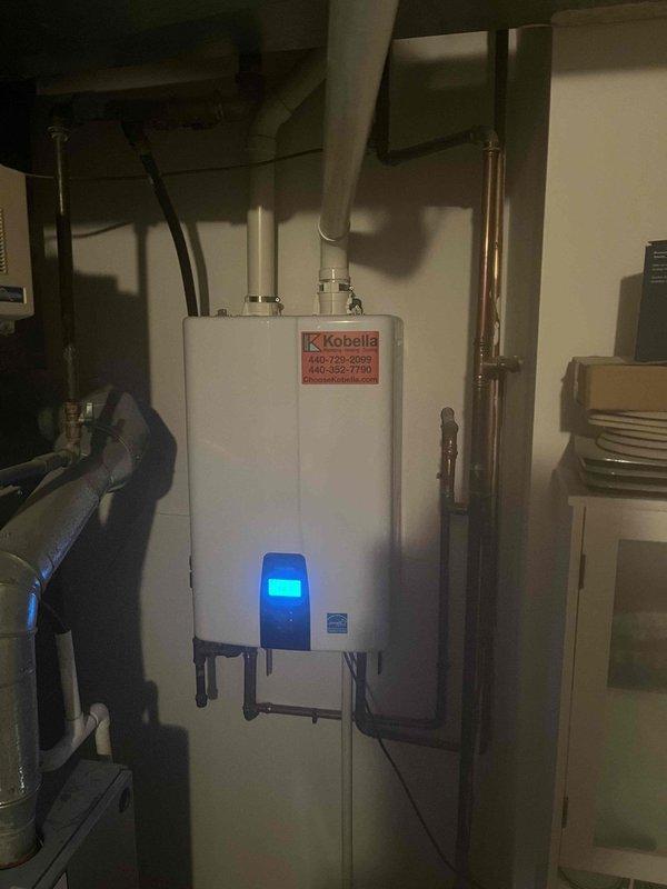 Responded to service call for 2-year-old Navien tankless water heater producing lukewarm water. Performed diagnostic inspection of unit, accessed internal components including heat exchanger, burner assembly, and control boards. Identified issue affecting proper heating operation, completed necessary repairs to restore full hot water temperature output, and verified system functionality before closing service panel.
