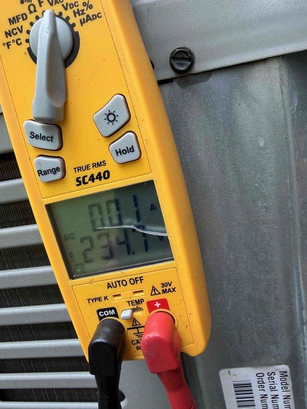 Responded to service call for 15-year-old air conditioning system reported as not cooling and never operating efficiently. Performed diagnostic testing using electrical meter to measure voltage and amperage at the outdoor condensing unit, recording 237.7 volts at the equipment. Inspected and tested the compressor contactor and electrical connections, removing and examining the three-pole contactor assembly for signs of wear, pitting, or failure. Evaluated the condition of the condenser coil fins and overall system components to determine the cause of cooling failure and poor historical performance.