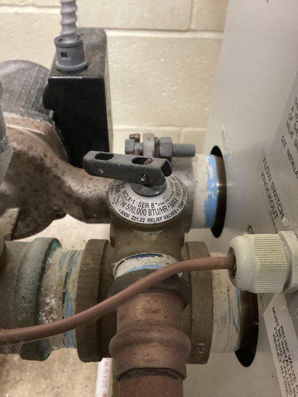 Responded to commercial boiler service call and performed system inspection. Documented pressure relief valve assembly (Cash Acme Type FVX-5C, 3/4", rated 150 PSI at 210°F, 203,000 BTU/H capacity) and gas valve regulator (70,000 BTU/HR capacity) showing signs of age with mineral deposits and surface oxidation on copper piping connections. All components operational and within specifications at time of inspection.