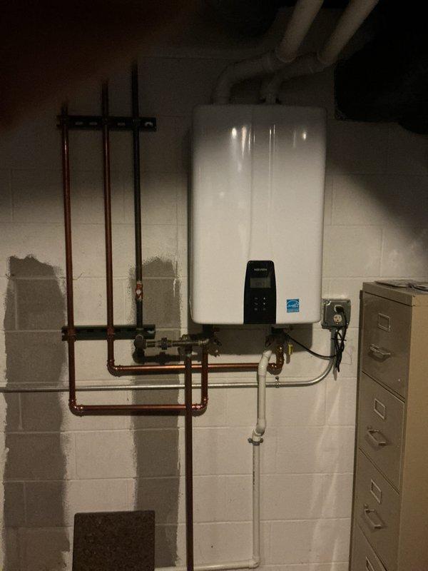 Completed plumbing membership inspection at residential property. Performed comprehensive visual assessment of Navien NPE-240S2 tankless water heater installation, including examination of copper supply manifold system with isolation valves, PVC condensate drain line, electrical disconnect, and all associated piping connections. Documented equipment condition and installation configuration with photographs, confirming unit operational status and proper mounting of all components per manufacturer specifications.