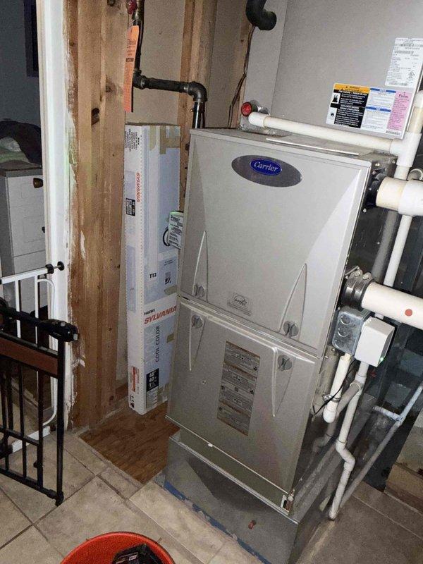 # HVAC Service Completed

Responded to service call for 16-year-old Carrier air conditioning system experiencing no cooling output and electrical flickering during operation. Upon arrival, performed diagnostic assessment of indoor air handler unit located in utility room.

Conducted electrical testing using digital multimeter to measure voltage and amperage at unit connections. Observed abnormal electrical readings consistent with reported flickering issue. Inspected all electrical connections, wiring terminals, and circuit components for signs of arcing, overheating, or loose connections that could cause voltage fluctuations.

Evaluated compressor operation and capacitor function to determine cause of no cooling condition. Checked refrigerant lines, condensate drain system with multiple PVC drain lines, and overall system integrity. Documented equipment condition through photographic evidence showing unit configuration, piping arrangement, and electrical testing procedures.

System re