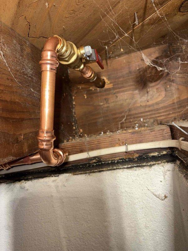 Installed new outdoor spigot with copper supply line assembly including shutoff valve with red handle in unfinished utility space. Customer inquired about promotional discount for second spigot installation following recent previous installation completed two weeks prior.