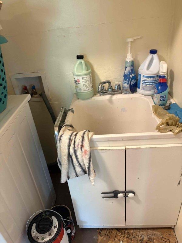 Responded to service call for leak under bathroom sink and trickling bathtub faucet. Inspected utility room sink plumbing and identified leak source at P-trap connections beneath basin. Tightened slip-joint fittings on white PVC drain assembly to eliminate water seepage. Verified all drainage components were properly sealed and functioning correctly. Addressed bathtub faucet issue by examining trim and internal mechanisms to stop persistent trickling water flow. Completed repairs and tested both fixtures to confirm leak resolution and proper operation.