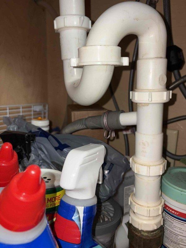 Responded to service call for leak under bathroom sink and trickling bathtub faucet. Inspected utility room sink plumbing and identified leak source at P-trap connections beneath basin. Tightened slip-joint fittings on white PVC drain assembly to eliminate water seepage. Verified all drainage components were properly sealed and functioning correctly. Addressed bathtub faucet issue by examining trim and internal mechanisms to stop persistent trickling water flow. Completed repairs and tested both fixtures to confirm leak resolution and proper operation.