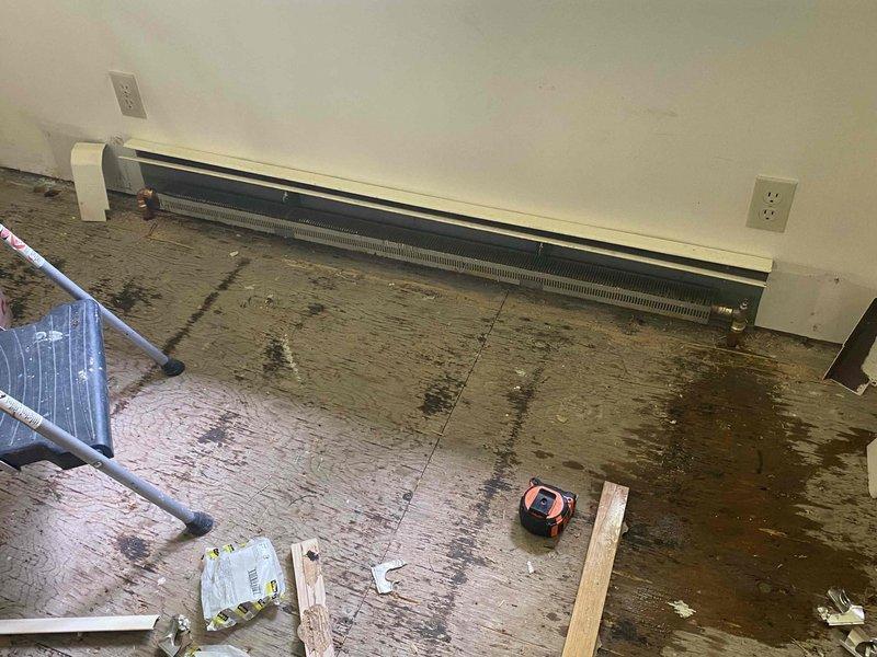 Completed installation of K84 Twin-Flo hot water coil with fan assist unit beneath new sink location in crawl space area. Modified existing fin tube baseboard heating system by shortening 7-foot section to 5 feet in dining room to accommodate room layout changes.