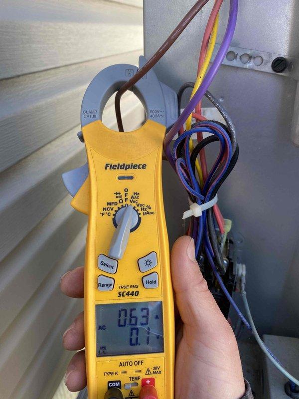 Completed prepaid cooling maintenance on outdoor air conditioning unit. Performed comprehensive electrical diagnostics using digital multimeter, measuring voltage readings at capacitor and electrical components to verify proper system operation. Capacitor tested at 23.5 volts with all wire connections secure. Conducted amperage measurement on brown wire using clamp meter, recording 0.63 amps, which falls within normal operating parameters. All electrical connections, including red, yellow, purple, and black wires, inspected and found properly secured with appropriate wire management. Condenser coil and unit exterior show normal weathering with minor dirt accumulation consistent with outdoor installation. System operating within manufacturer specifications with no deficiencies noted.